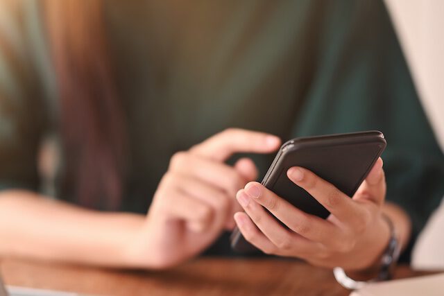 スマホでお問い合わせをする女性 | 緑のタニムラ
