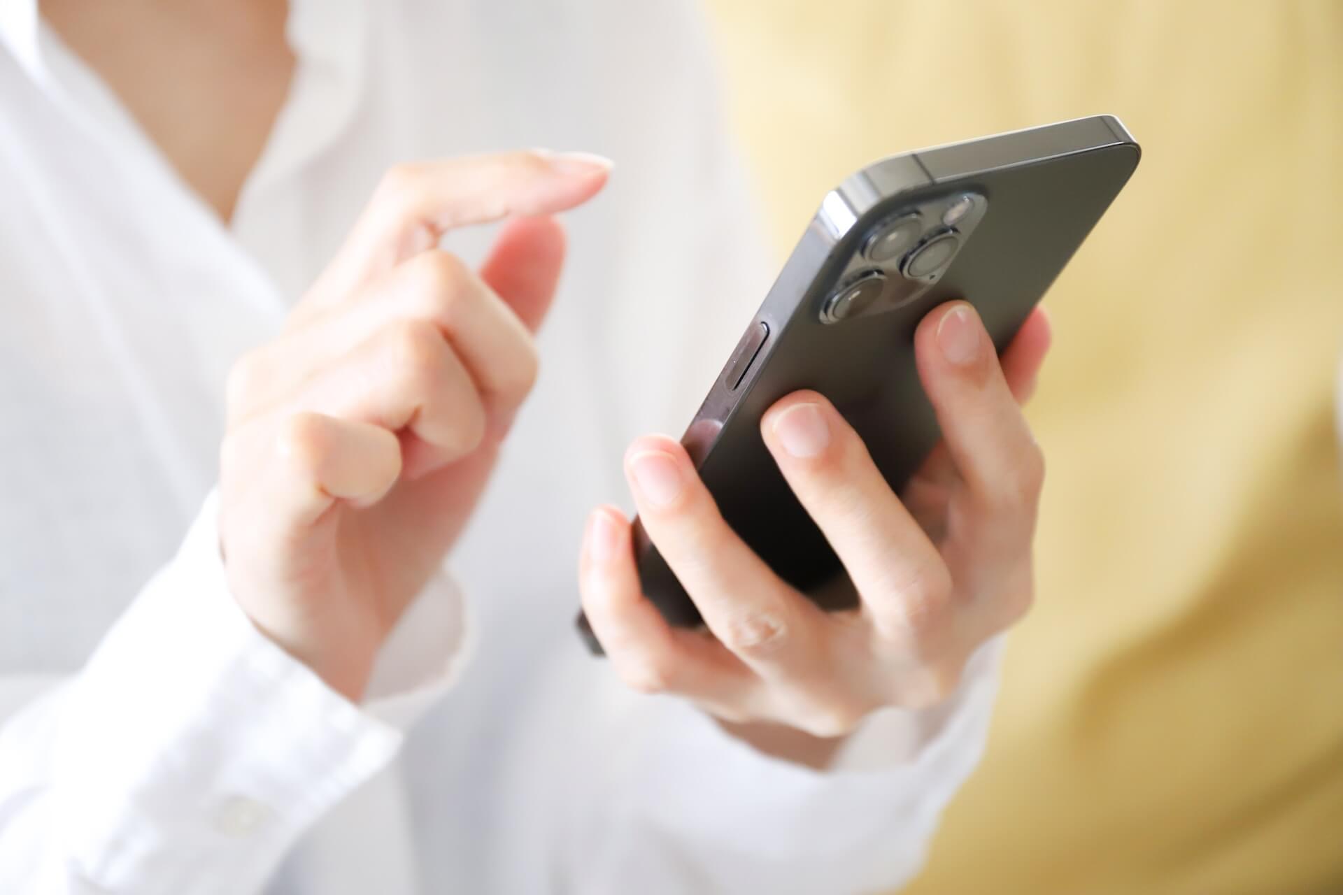 スマホを操作する女性 | 緑のタニムラ